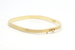 Yellow metal clasp bangle, matt gold finish to the outer edge, stamped 9ct, weighing approximately
