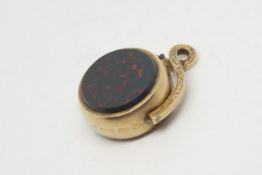 Gold fob, one side is set with a circular cut bloodstone, the other is set with a roulette style