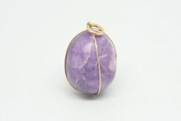 Quartz egg pendant, with a yellow metal wire surround stamped 18ct