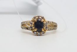 Sapphire and paste ring, central oval cut sapphire, surrounded by colourless paste stones and