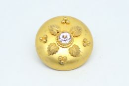 Gem set brooch, central colourless stone, set in a yellow metal circular surround, tested as base