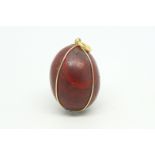 Red jasper egg pendant, with a yellow metal wire surround stamped 18ct