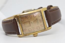 Gentlemen's Doxa Clamshell Vintage Wristwatch, rectangular patina dial with Arabic numerals and a