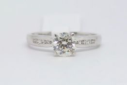 Diamond ring, round brilliant cut diamond weighing an estimated 1.05ct, with channel set round