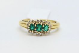 Emerald and diamond cluster ring, three round cut emeralds, surrounded by round brilliant cut