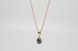 Sapphire and diamond cluster pendant, central oval cut sapphire, surrounded by brilliant cut