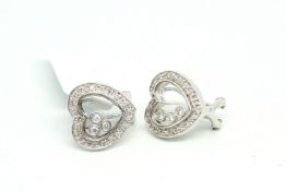 Diamond earrings, heart design set with three floating diamonds between two panes of glass, and a