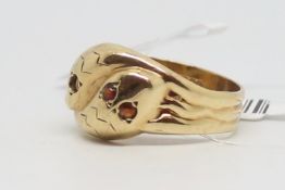 Double snake ring, two coiled snakes set with garnet set eyes, mounted in 9ct gold, ring size W, a/