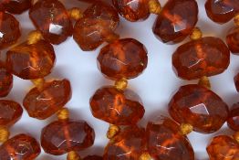 Large row of early faceted amber beads, 55 graduating beads, from approximately 15mm to 25mm