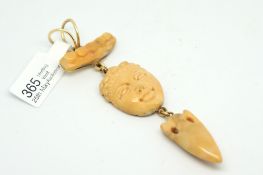 Coral pendant, carved coral spear head suspended from a carved coral in the form of a face,