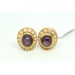 Pair of star ruby and diamond earclips, central oval cabochon cut star rubies measuring 9 x 8mm,