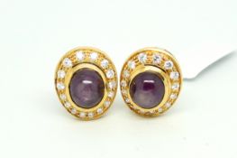 Pair of star ruby and diamond earclips, central oval cabochon cut star rubies measuring 9 x 8mm,