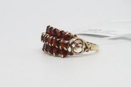 Garnet cluster ring, three rows of round cut garnets claw set with decorative shoulders, in 9ct