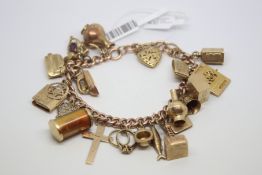 Gold charm bracelet, 9ct yellow gold curb link bracelet with approximately twenty-three charms,