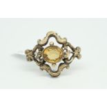 Victorian citrine brooch, central oval cut citrine within an open ornate setting, brooch fitting and
