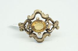 Victorian citrine brooch, central oval cut citrine within an open ornate setting, brooch fitting and