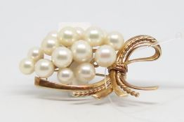 Mikimoto pearl brooch, cluster of cultured pearls measuring between 5.2-6.8mm, with a yellow metal