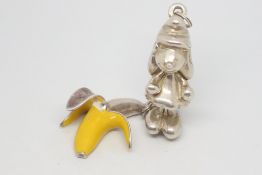 Two silver pendants, including a heavy Smurfette pendant, measuring 43mm, together with a banana