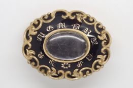 Gilt metal mourning brooch, central locket compartment, black enamel surround with yellow metal