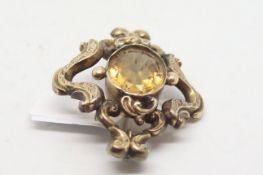 Victorian citrine brooch, central oval cut citrine within an open ornate setting, brooch fitting and