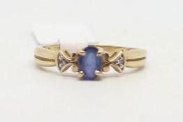 Sapphire and diamond ring, central oval cut sapphire, with a diamond set to each shoulder, mounted