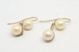 A pair of pearl drop earrings, two pearls set to each drop, mounted in yellow metal