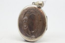 A white metal locket, engraved detail to front, tested as silver