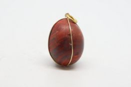 Red jasper egg pendant, with a yellow metal wire surround stamped 18ct