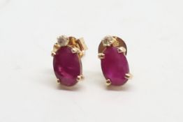 Pair of ruby and diamond stud earrings, oval cut rubies and a single cut diamond, mounted in 9ct