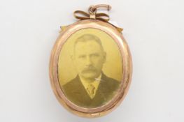 Oval yellow metal picture frame locket, with a bow detail to the top, and a pendant loop, stamped