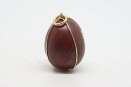 Red jasper egg pendant, with a yellow metal wire surround stamped 18ct