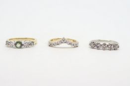 Three gem-set rings, including a diamond set wishbone ring in 9ct gold, a five stone diamond ring in