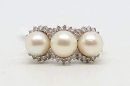 Three stone pearl and cubic zirconia ring, three 6.8mm pearls, surrounded by cubic zirconias,