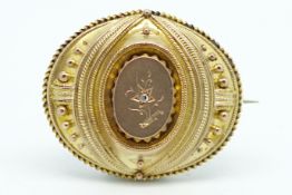 Diamond set Etruscan style brooch, in yellow metal with a locket back