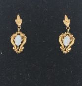 A pair of opal drop earrings in 9ct yellow gold