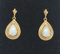 A pair of opal drop earrings, pear cut opals, in a 9ct yellow gold setting, post and butterfly