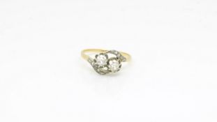 An 18ct gold and platinum diamond crossover ring. UK size N 1/2. The shoulders are set with rose cut