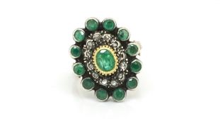 Emerald and diamond cluster ring, central oval cut emerald, rose cut diamonds and a further border
