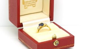 Cartier - Sapphire and diamond ring, central oval cut sapphire set with a pear cut diamond to each