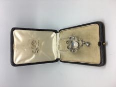 A platinum diamond and moonstone brooch / necklace in a fitted case. French import marks. The old