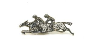 Horse racing brooch, two galloping horses with jockeys, set with diamonds, in silver gilt