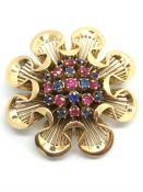 Gem set brooch, central cluster of rubies, sapphires and emeralds within a gold wave surround,