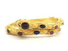 Multi gem set dragon bangle, carved bangle, set with oval sapphires and rubies, hallmarked 22ct