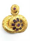 Foil backed garnet brooch, cluster of garnets, within a yellow metal knot, with beaded detail,