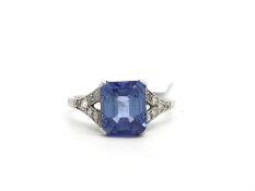 A blue gemstone in a white metal mount with old cut diamond set shoulders, ring size K