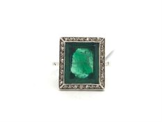 A green paste ring in a white metal mount with a halo of white stones, ring size J 1/2