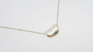 TIFFANY & CO- A silver Elsa Peretti coffee bean pendant on a silver chain, both signed, length