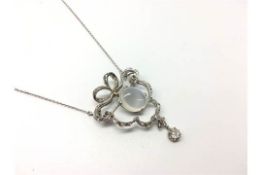 A platinum diamond and moonstone brooch / necklace in a fitted case