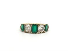 Antique emerald and diamond carved half hoop ring, two old cut diamonds set in between three