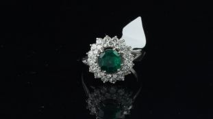 Emerald and diamond ring, central round cut emerald weighing a estimated 1.40ct with a double